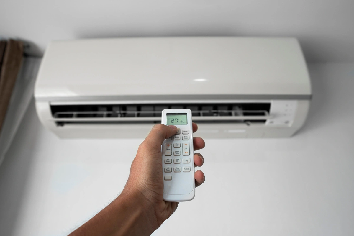 Utilisation d'une télécommande pour régler un système de climatisation réversible.