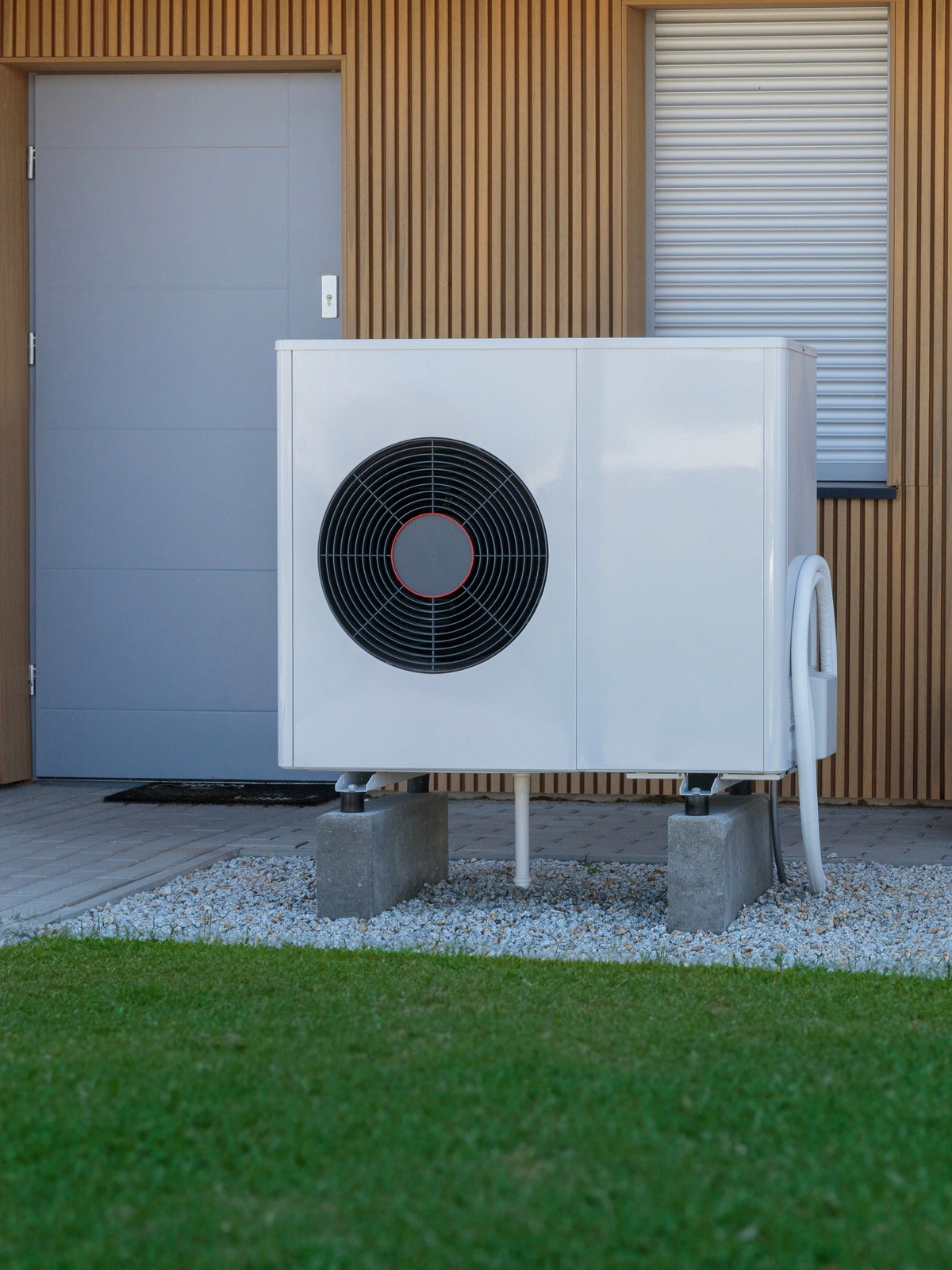 Pompe à chaleur réversible installée dans le jardin d'une maison.