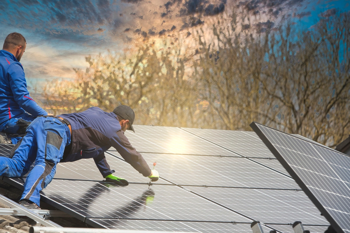 Installation de panneaux photovoltaïques sur un toit par des techniciens.